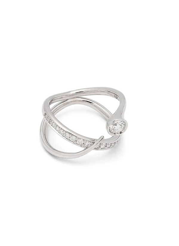 Moderno anillo de oro blanco de 18Kt, compuesto por 2 bandas, una lisa que acaba en un chatón que lleva engastado un diamante ta