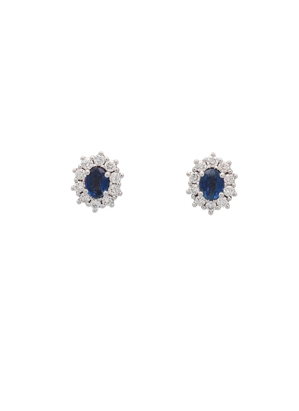 Pendientes de oro blanco de 18Kt. Pequeña orla de 8,30x6,40mm con un zafiro oval y 10 diamantes talla brillante alrededor. El pe