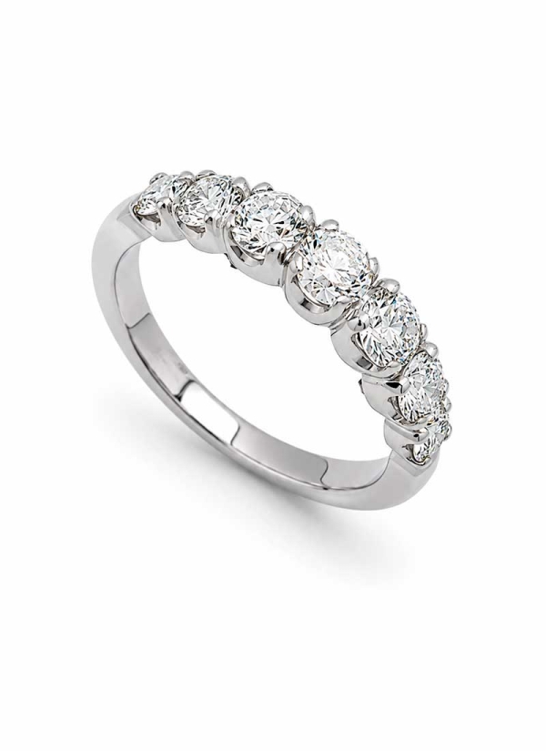 Media alianza de oro blanco de 18Kt hecha a mano. 7 diamantes talla brillante engastados en garras y en disminución. El mayor, e